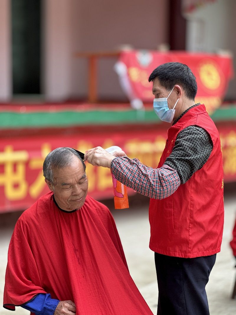 圖三：黨員志愿者為老人理發(fā).jpg